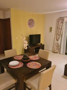 a dining room with a table with chairs and a television at Unique Poolside Apartment in Santa Maria
