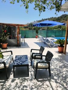 a patio with chairs and a table and an umbrella at Villa angel in Sarigerme