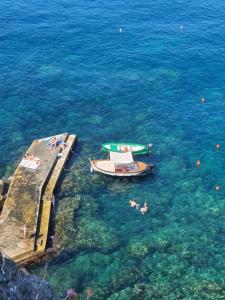 a boat and people swimming in the water at Casa caterina in Corniglia +5 photos