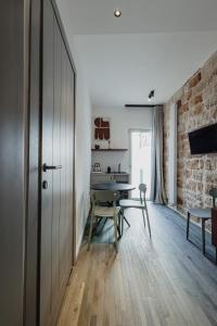 a room with a ping pong table and a brick wall at Monachile Apartments - Housea in Polignano a Mare