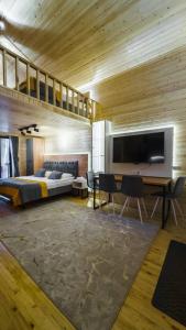 a bedroom with a bed and a table and a television at Ski Paradise Karakol in Karakol +180 photos