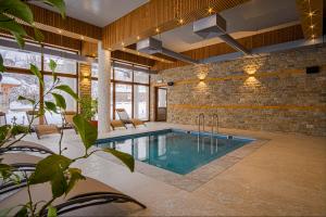 a swimming pool in a room with a brick wall at Spa Villas Daffi in Smolyan