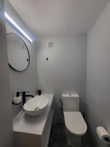 a bathroom with a white toilet and a sink at Aleka's Rooms in Tinos +13 photos