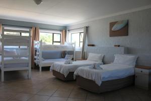 a bedroom with two beds and a couch at Pili Pili Beach Cabanas in Sedgefield