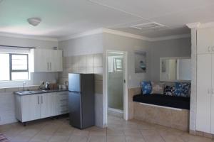 a kitchen with a refrigerator and a bed at Pili Pili Beach Cabanas in Sedgefield