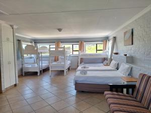 a bedroom with two bunk beds and a couch at Pili Pili Beach Cabanas in Sedgefield