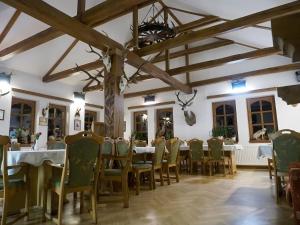 jadalnia ze stołami i krzesłami w budynku w obiekcie Rókabérc Vadászház Hotel w mieście Erdőbénye