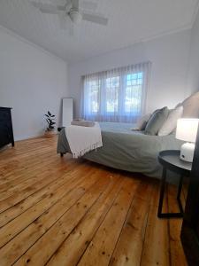 a bedroom with a bed and a wooden floor at Barnard Bungalow in Bendigo