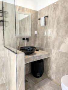 a bathroom with a sink and a glass shower at Mediterranean Beauty in Skiathos