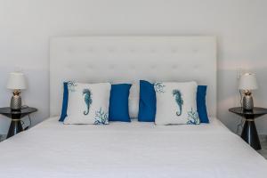a bed with blue and white pillows on it at Mediterranean Beauty in Skiathos