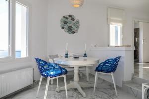 a kitchen with a white table and two blue chairs at Mediterranean Beauty in Skiathos +15 photos