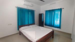 a bedroom with a bed and two blue windows at Azza Home in Cochin +30 photos