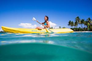 a woman is sitting on a kayak in the ocean at Plantation Island Resort in Malolo Lailai
