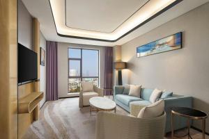 a living room with a couch and a tv at Courtyard by Marriott Nanchang in Nanchang +29 photos