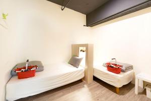 two beds in a room with two bags on them at Ease Single Inn in Taichung