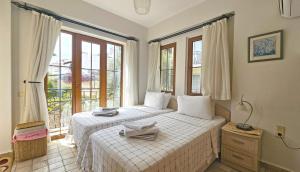 Dos camas en una habitación con dos ventanas. en Kalkan Town Apartment, en Kas 19 fotos más