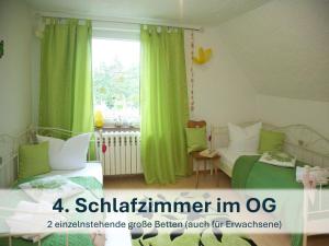 1 Schlafzimmer mit 2 Betten und einem Fenster mit grünen Vorhängen in der Unterkunft Ferienhaus mit Reetdach Gerdi in Heringsdorf