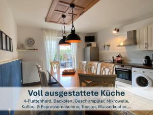 eine Küche mit Tisch und ein Esszimmer in der Unterkunft Ferienhaus mit Reetdach Gerdi in Heringsdorf