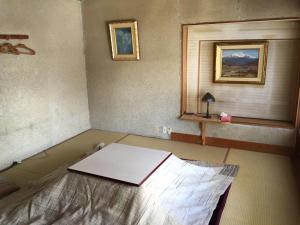 a room with a bed and a window in it at Tsugaike Ski House in Otari