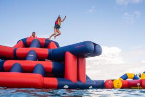 two people jumping off an inflatable raft in the water at Plantation Island Resort in Malolo Lailai +105 photos