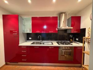 a kitchen with red cabinets and a sink at Apartment Marilù in Greve in Chianti