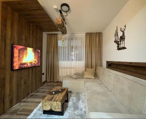 a living room with a fire on the wall at Gencian Resort KOPAONIK in Kopaonik