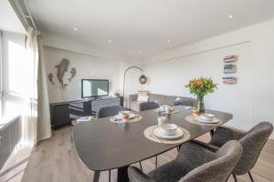 a dining room with a table and chairs and a couch at kindvriendelijk appartement "Sereno", De Haan-Wenduine in Wenduine