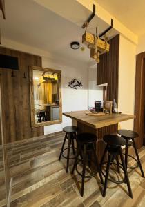 eine Küche mit einer Theke mit Hockern und einem Spiegel in der Unterkunft GENCIAN RESORT in Kopaonik