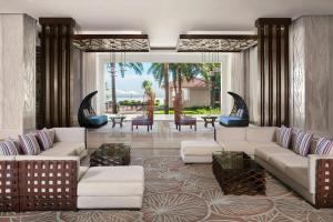 a living room with white couches and chairs at Renaissance Danang Hoi An Resort & Spa in Hoi An