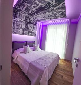 a bedroom with a bed with purple lighting at Case Vacanze 106 Maison De Charme in Giovinazzo