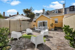 a patio with a table and chairs and an umbrella at Historic 4 Bedroom Townhouse in Launceston
