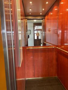 a dressing room with wooden cabinets and a mirror at Cosy Rooftop Downtown Crans-Montana with Stunning View and Swimming Pool in Crans-Montana