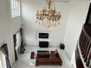 een woonkamer met een kroonluchter en een bank bij Biệt Thự Nguyên Căn đường Trần Phú Vũng Tàu - View Biển Bãi trước - Hồ bơi sân vườn riêng - 7 phòng ngủ lớn in Vung Tau