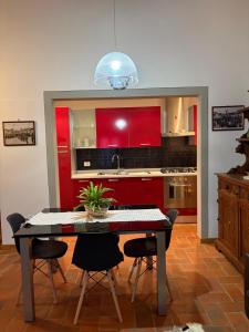 a kitchen with a table and chairs and red cabinets at Apartment Marilù in Greve in Chianti