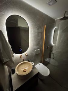 a bathroom with a sink and a mirror at Armonia Suites Livadi Arachovas in Arachova