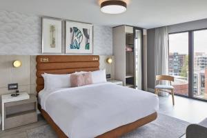 a bedroom with a white bed and a large window at AC Hotel by Marriott Greenville in Greenville +71 photos