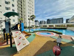 a swimming pool with a slide and a playground at Huge 2BR Condo in IT Park Cebu in Cebu City