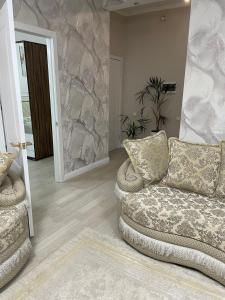 a living room with a couch and a stone wall at Apartment 33 in Astana +1 photo