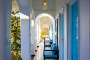 a hallway with blue chairs in a house at ELIVAAS Queens Town 6 BHK Pet-Friendly Retreat with Pvt Pool & Restro in Udaipur