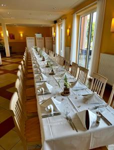 a long table with white tablecloths and napkins at JUFA Hotel im Brückenkopfpark - Jülich in Jülich