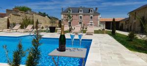 a bottle of wine on a table next to a pool at La Galuche-B&B & Studio in Angliers