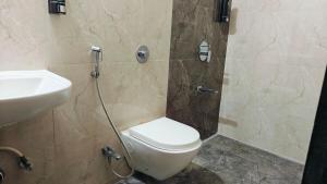 a bathroom with a toilet and a sink at Bamboo Stays 3bhk with Skylounge & pool in Pune +15 photos