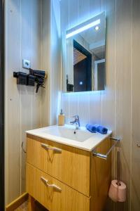a bathroom with a sink and a mirror at Charmant studio au cœur d une station des Vosges in Sondernach +49 photos