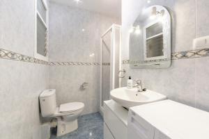 a white bathroom with a toilet and a sink at AlmeriaSuite Impressive Beach Views in Almería +26 photos