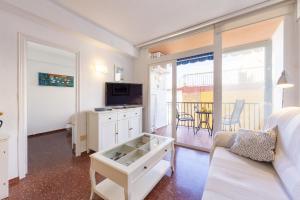 a living room with a couch and a tv at AlmeriaSuite Impressive Beach Views in Almería