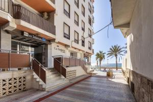 a building with stairs leading to the beach at AlmeriaSuite Impressive Beach Views in Almería