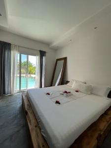 una camera da letto con un grande letto bianco con fiori sopra di Villa in Kiwengwa con piscina a Gulioni