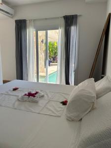 un letto bianco con fiori rossi sopra di Villa in Kiwengwa con piscina a Gulioni Altre 49 foto