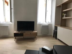 a living room with a flat screen tv on a table at Coeur de Saint Marcellin in Saint-Marcellin