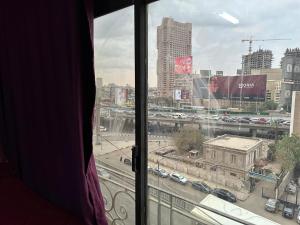 a window with a view of a city with cars at oasis Hotel in Cairo